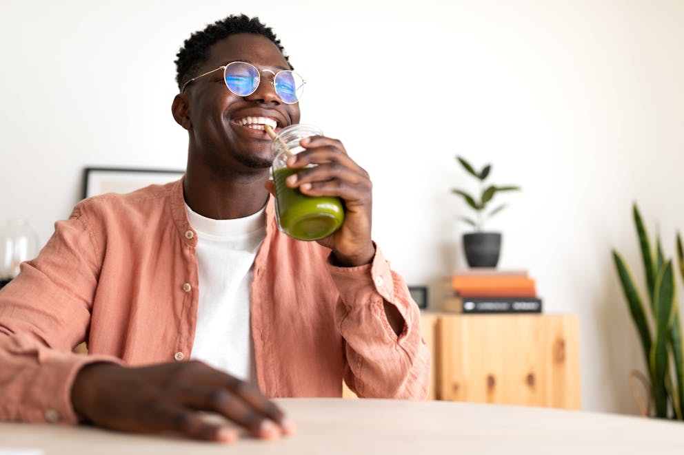 Man drinking a green smoothie