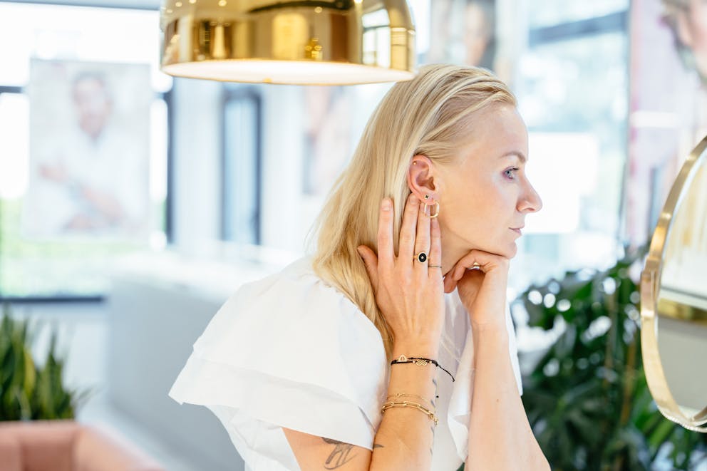 Woman checking her ear in the mirror