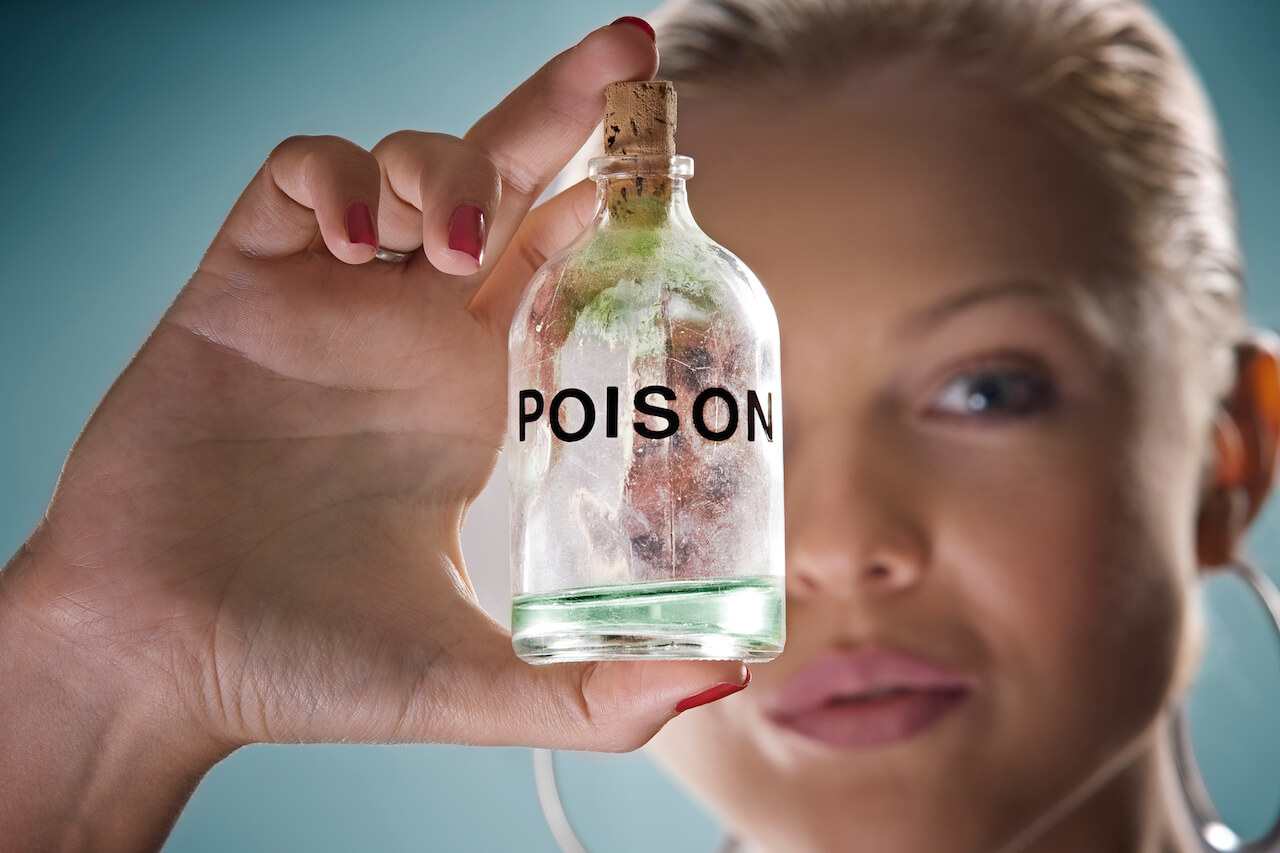 Woman holding bottle of poison | The Top 3 Reasons for Using Coconut Oil