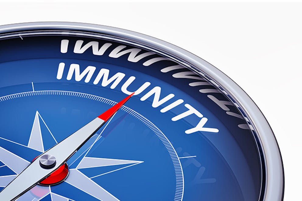 Close-up image of blue compass, red tip of needle pointing to word “immunity.”