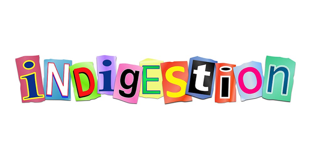 Cut out printed colorful letters arranged to spell indigestion, acid reflux concept.