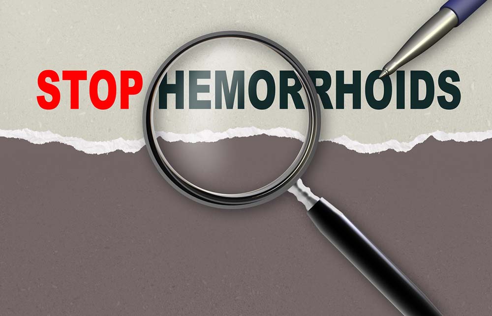 The words “Stop Hemorrhoids” under a magnifying glass with a pencil