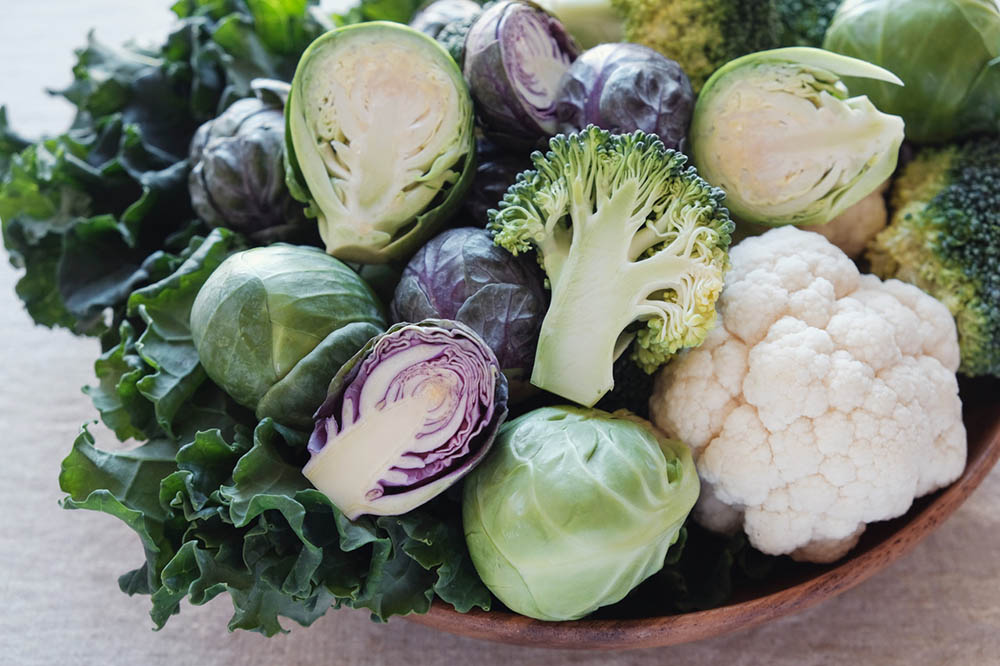 Assorted cruciferous vegetables including cauliflower, broccoli, kale, and Brussel’s sprouts