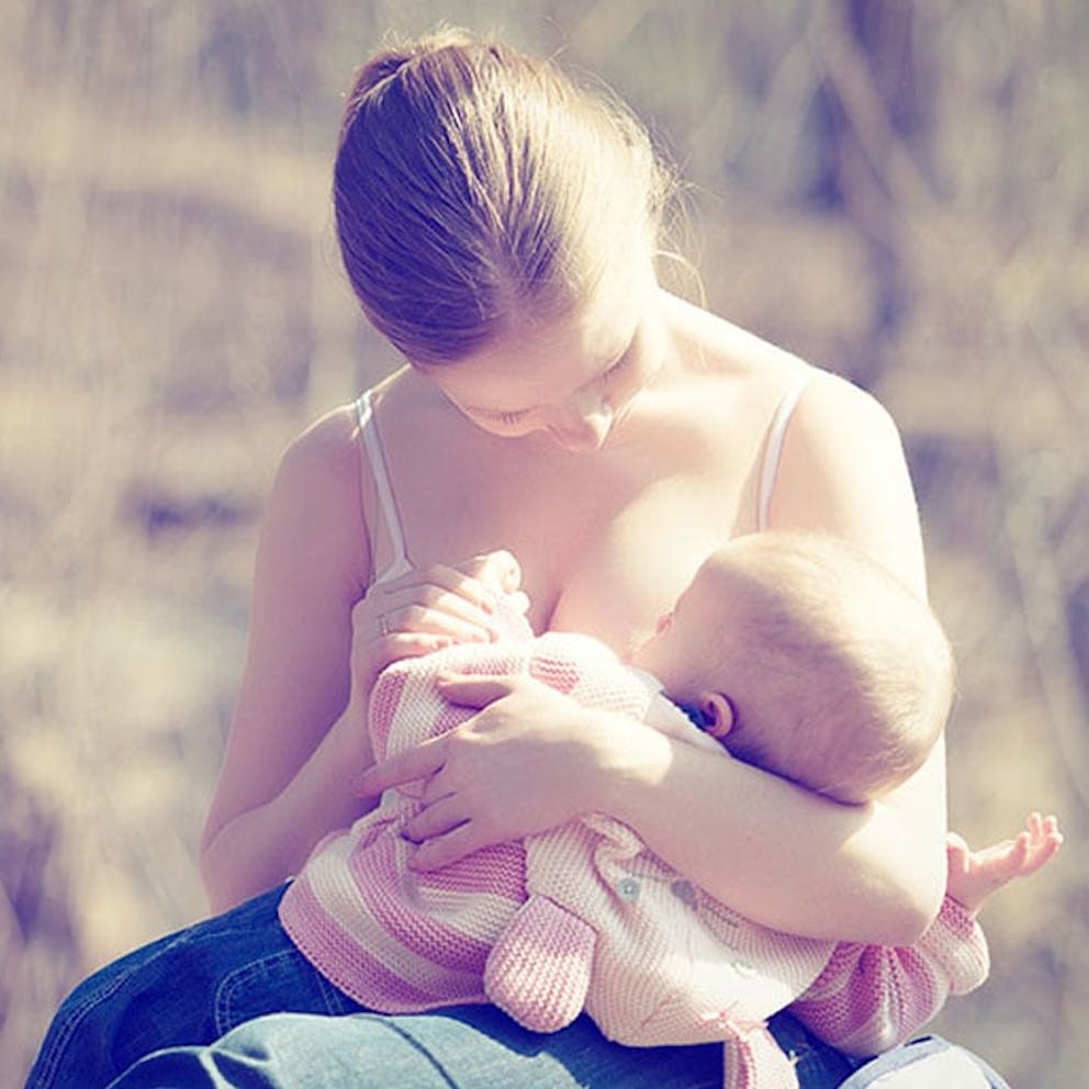 mother breastfeeding her baby outdoors