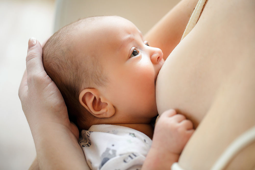 baby feeding at mom’s’ breast