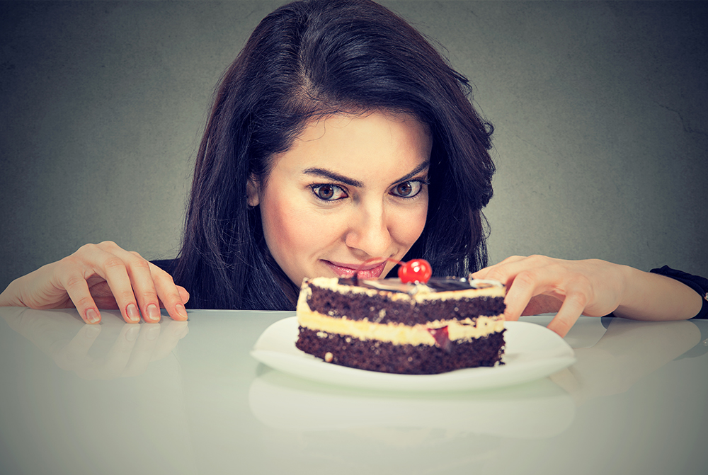 a woman craving a large piece of cake