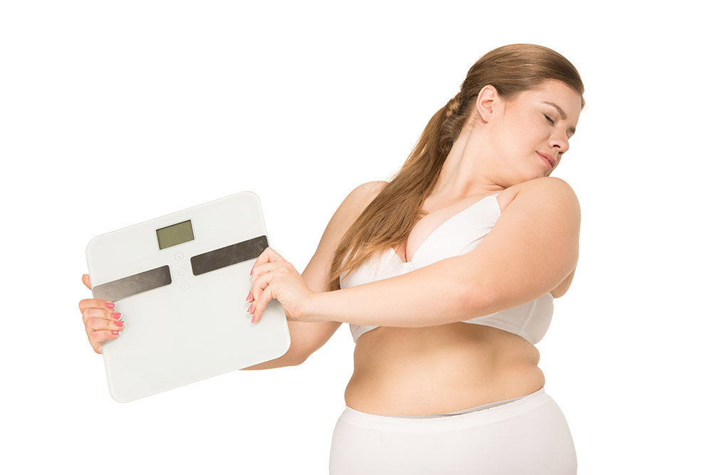 overweight woman holding a scale