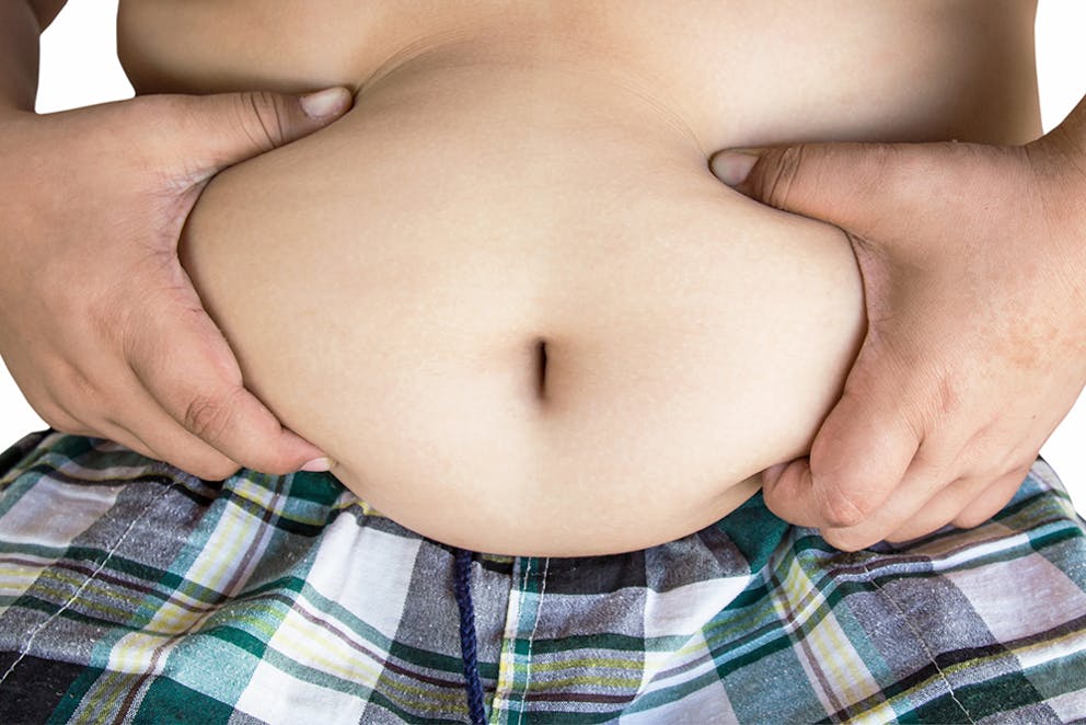 overweight child holding his stomach