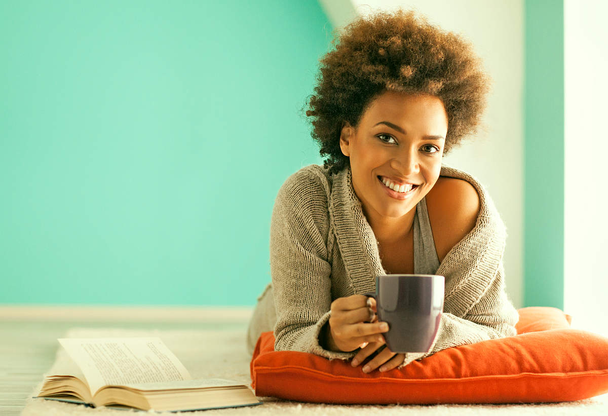Beautiful young African woman enjoying a cup of coffee while relaxing at home | Can Stevia Trigger Fat Storing Hormone?