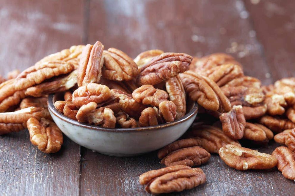 Pecan nuts on a rustic wooden table and pecan nuts in bowl | Low-Carb Keto Candied Pecans (Keto-Friendly Snacks) | candied pecans brown sugar