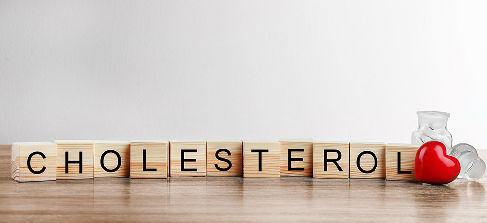 wooden cubes spelling the word cholesterol with a heart at the end