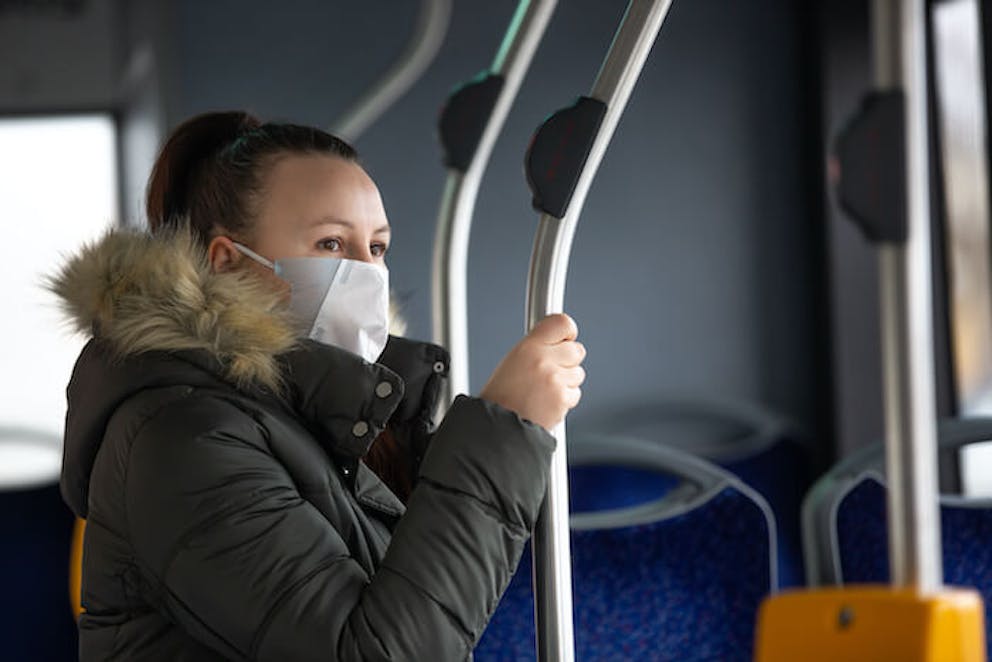 Woman in bus with facemask holding rail | Coronavirus and Zinc