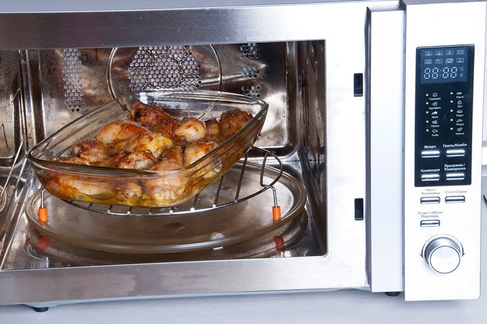 Chicken in glass dish in microwave, heating food in microwave-safe container, no plastic.