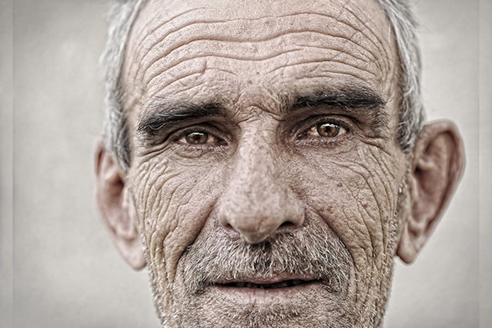 a photo of an old man with sagging ears and bushy eyebrows