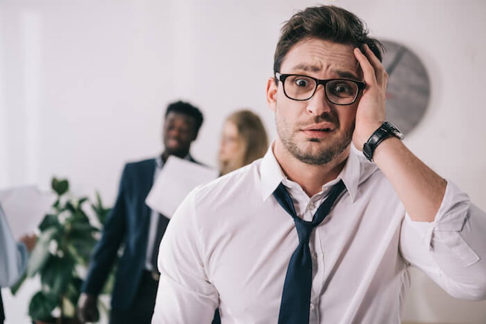 Man holding head in office | Eat More Magnesium Foods, and You'll Feel a Lot Better