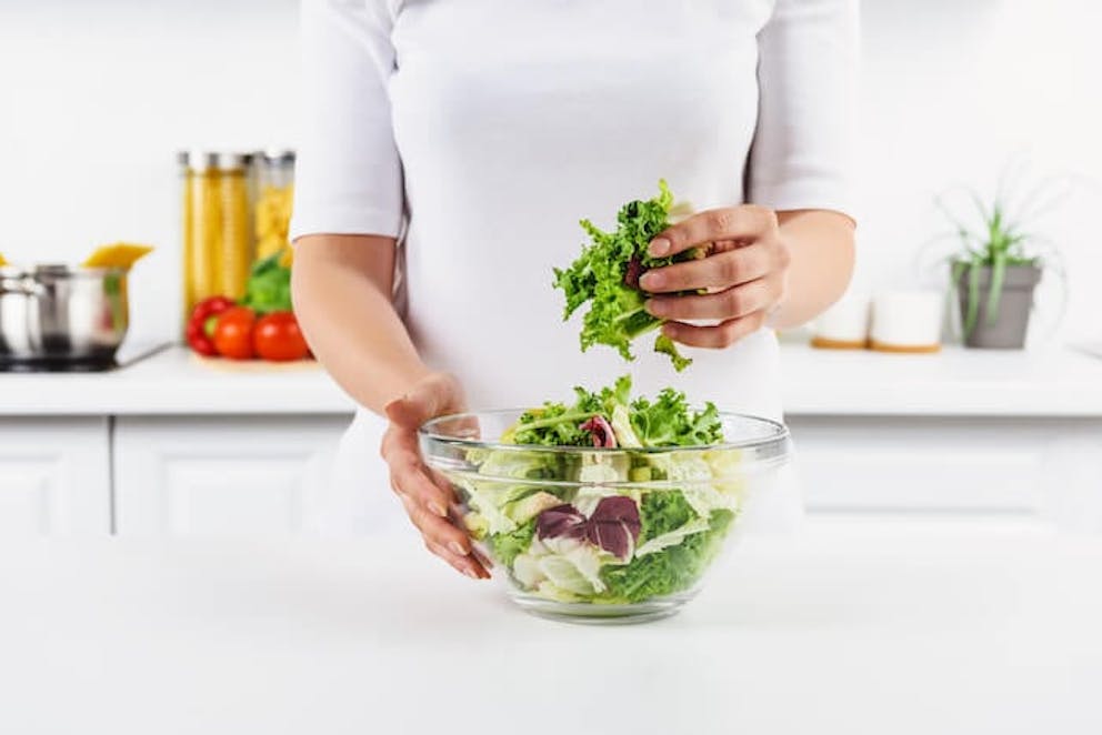 Woman making a salad with healthy magnesium foods | Eat More Magnesium Foods, and You'll Feel a Lot Better