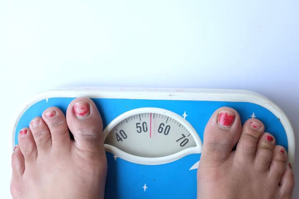 A close-up of a person’s feet standing on a scale | Gaining Weight During Lockdown? Do This!