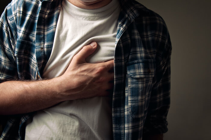 man grabbing chest during heart attack | How to Avoid Blood Clots, Strokes, and Heart attacks