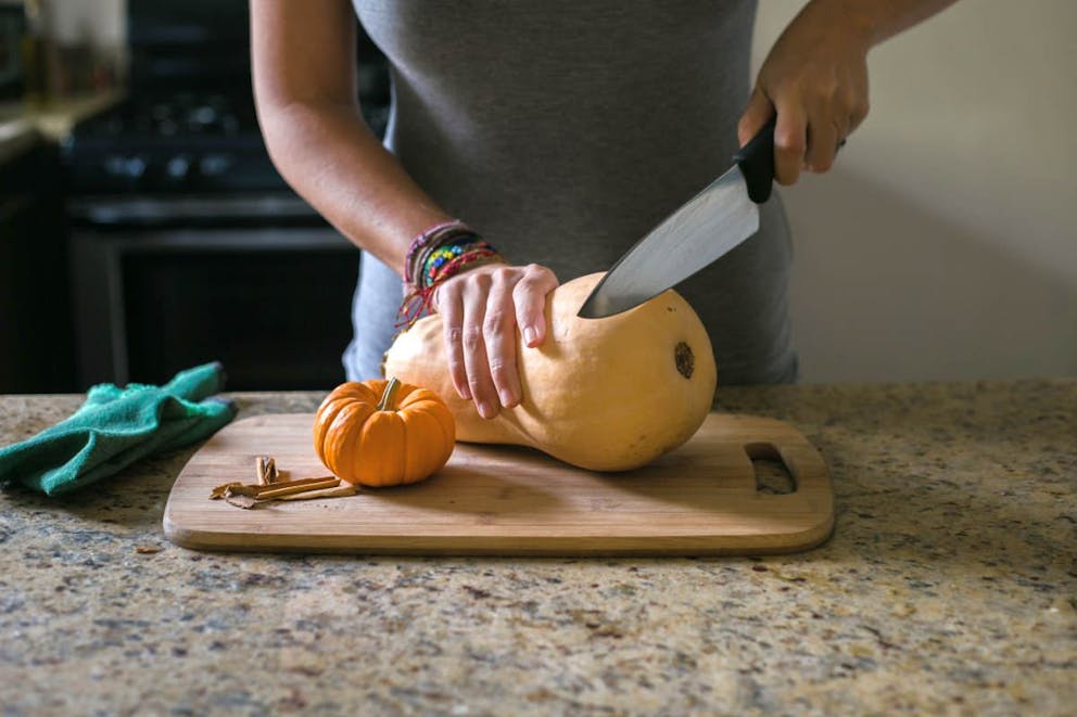 Woman cutting a whole butternut squash with a knife | Is Squash Keto-Friendly? (Butternut, Spaghetti, And Yellow Squash) | is squash keto?