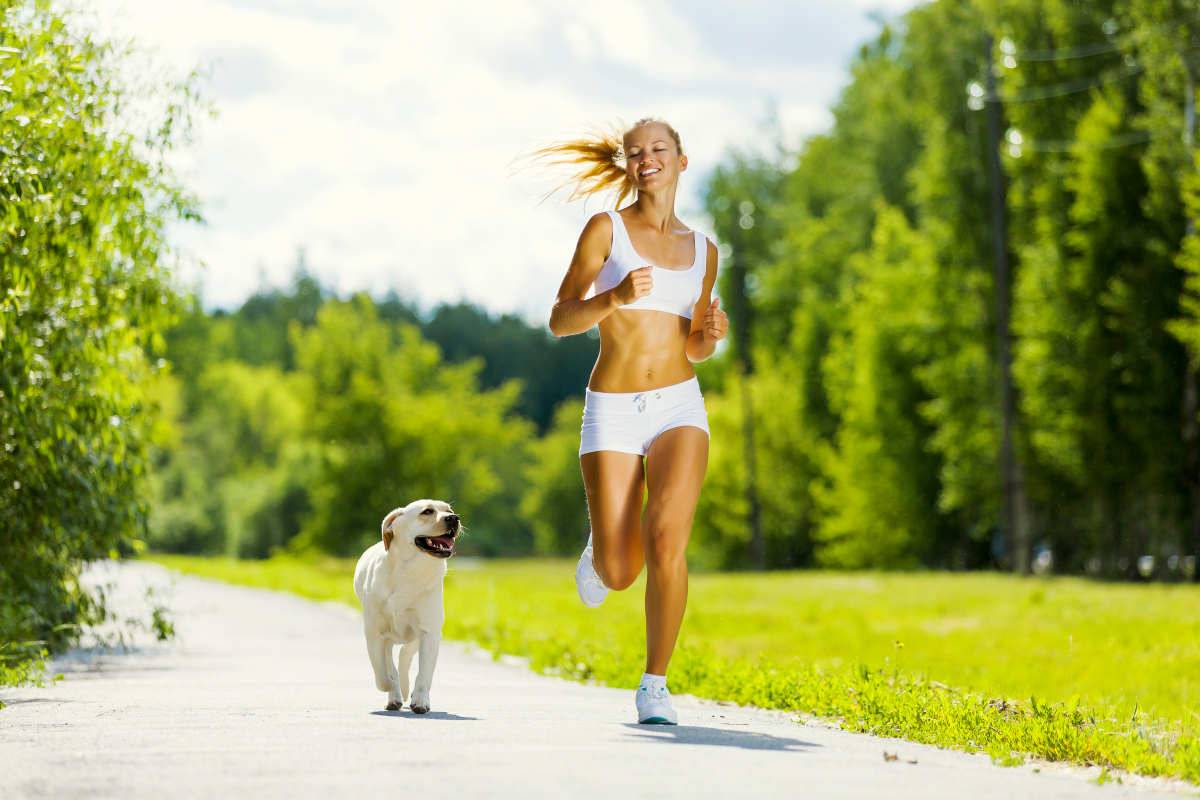 Young attractive sport girl running with dog in park | Understanding The Ketogenic Diet: What Is A Ketone? 
