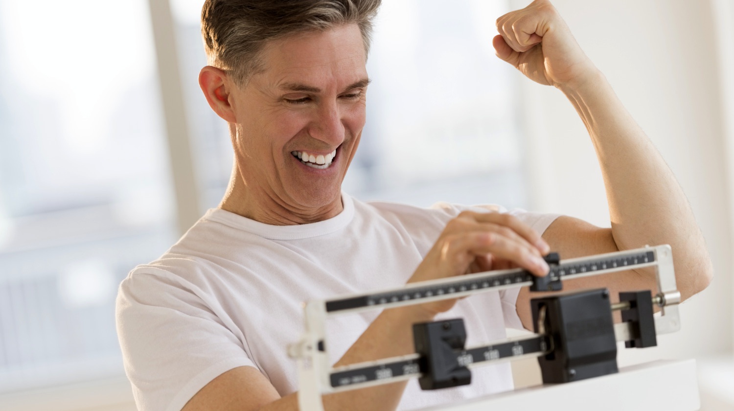 Featured | Excited mature man clenching fist while using balance weight scale at gym | The Importance of the NO CARB SNACKS Rule if You Want Weight Loss