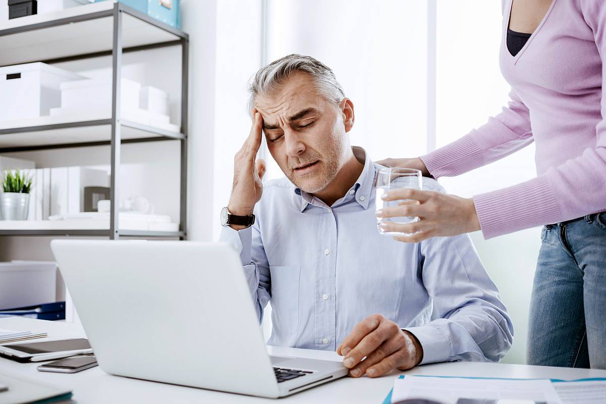Tired businessman in the office working at desk and having a bad headache | How To Reverse Hardening Of The Arteries (Atherosclerosis) | atherosclerotic heart disease