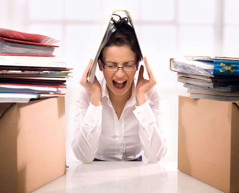 Woman stressed out with folder on head | Stress and Your Immune System