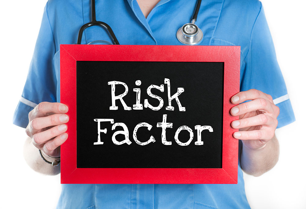 doctor holding a sign that says Risk Factor