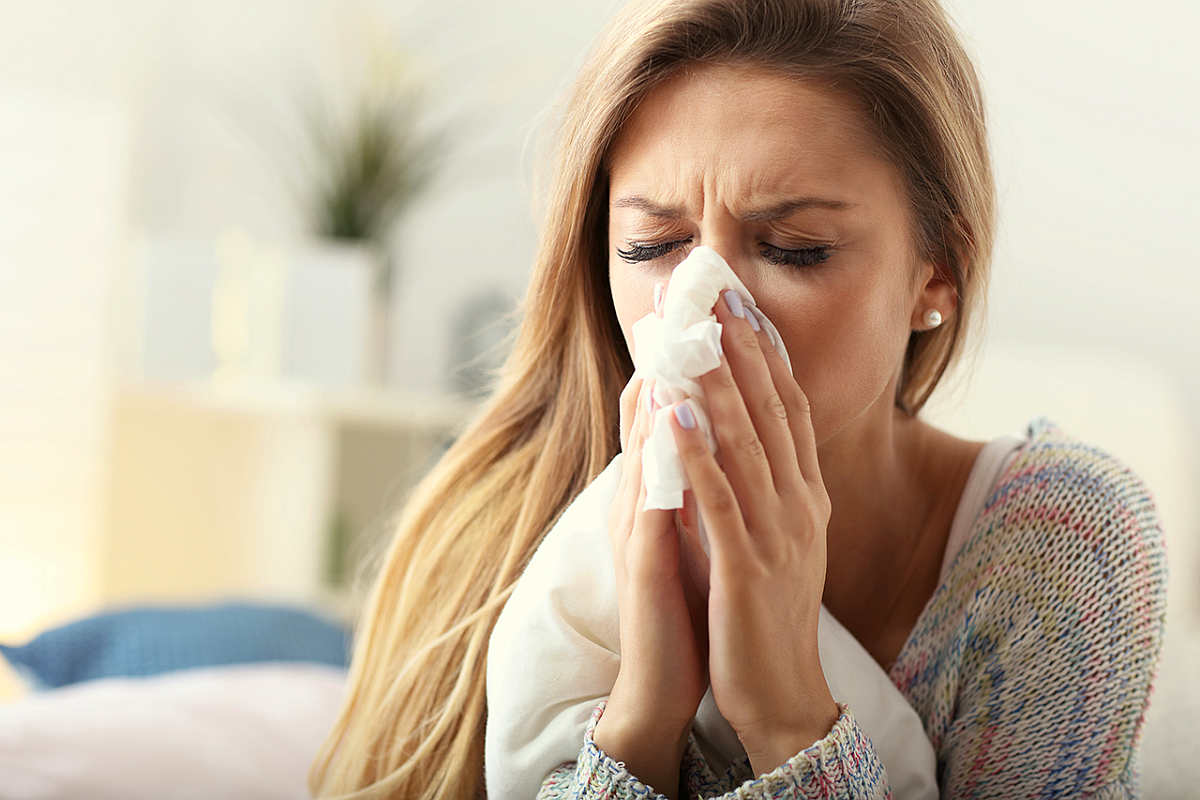Picture showing sick woman sneezing at home | The 7 Keto Common Myths and Lies