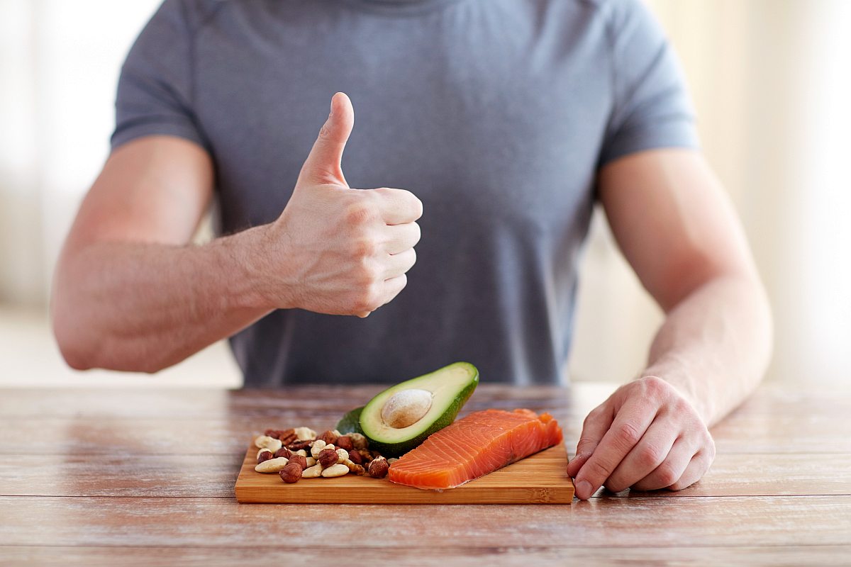 Close up of male hands showing thumbs up with food rich in protein on cutting board on table | The 9 Benefits of Apple Cider Vinegar