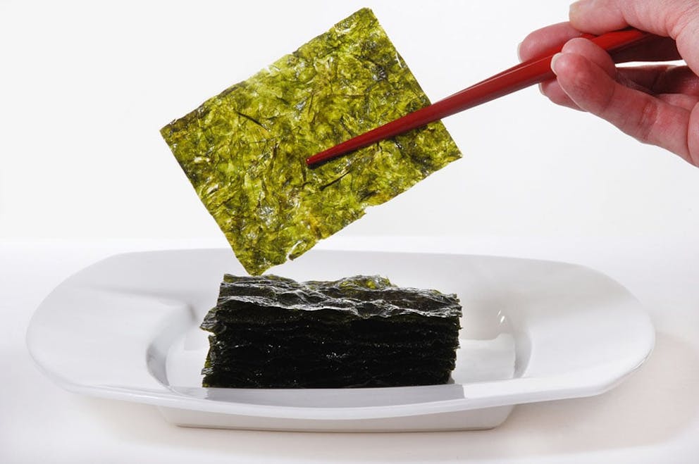 Pile of dry wakame seaweed on white background, healthy sea vegetable.