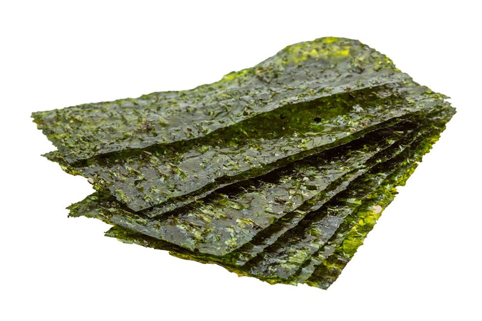 Sheets of nori stacked and fanned out isolated on a white background.
