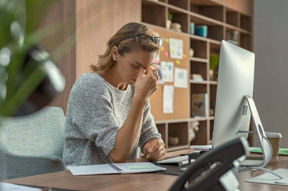 Mature creative woman working at office desk feeling tired | Fat Deficiency: What Are The Dangers Of Essential Fatty Acid Deficiency? | what are fatty acids