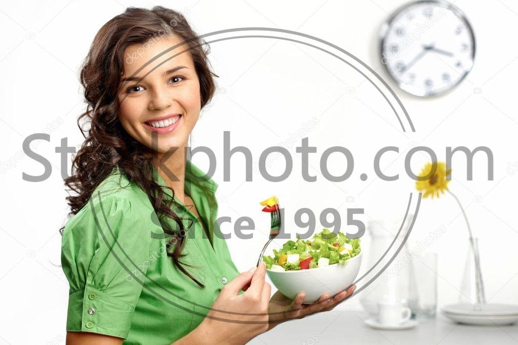 a healthy happy young woman eating a salad