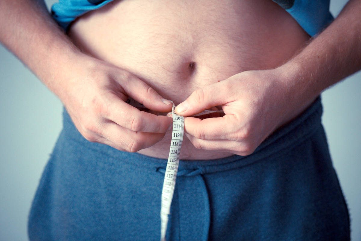 Man measuring belly with tape measure | The Dangers If You Quit Smoking Cold Turkey | what happens when you quit smoking