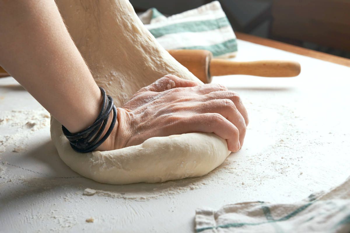 Man kneading dough over table | The Healthiest Bread Recipe In The World