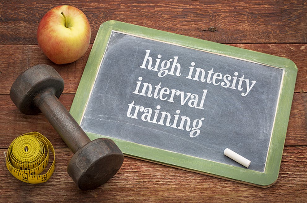 high intensity interval training written on a chalkboard with a dumbell and apple next to it