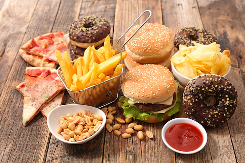 a photograph of junk foods like pizza, donuts, chips, and fries