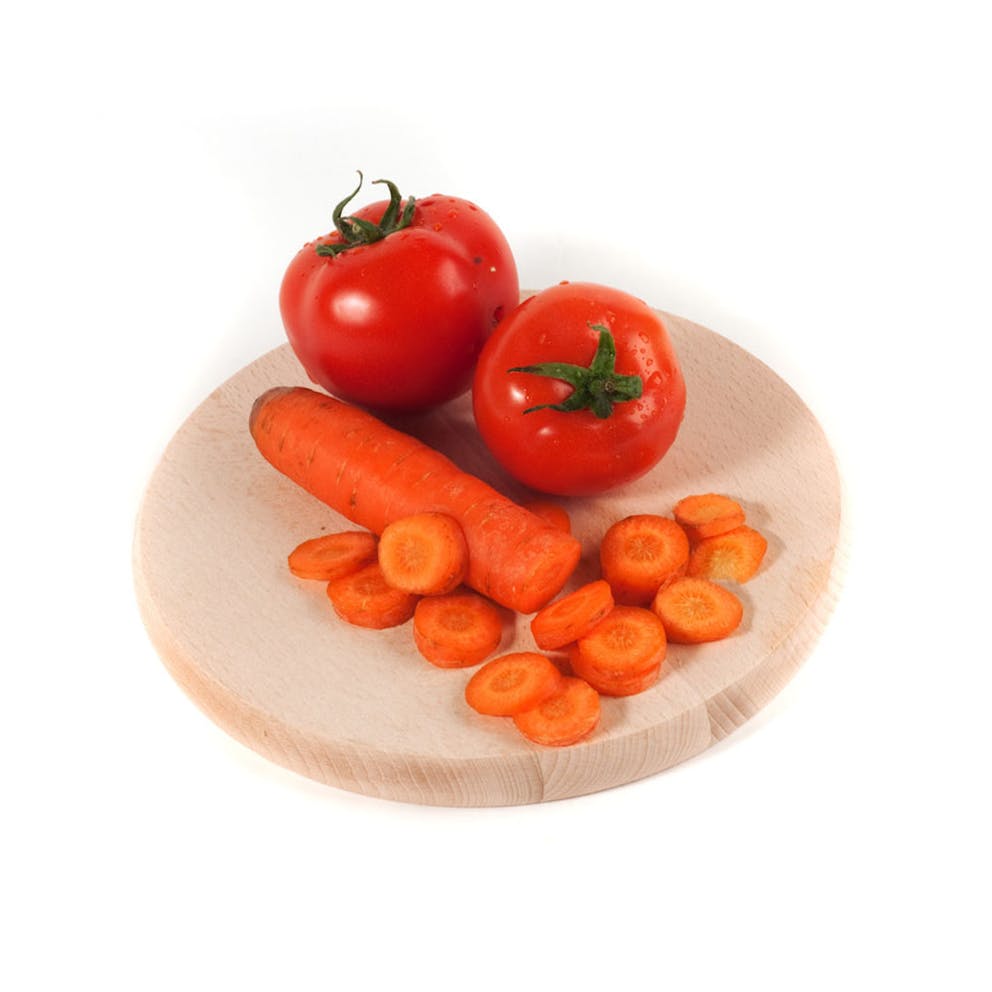 Fresh tomatoes and a sliced carrot on a wooden cutting board and white background.