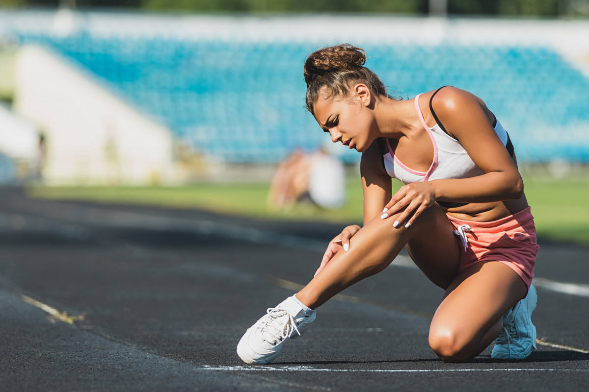 Runner suffering from leg cramp on the track | The Top Symptoms Of A Potassium Deficiency