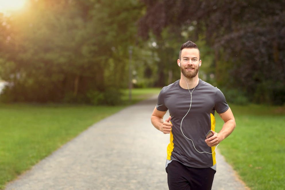 Fit bearded young man jogging through a park  | Understanding Protein's Role In Fat Burning And Weight Loss | Understanding Protein | how much protein should I eat
