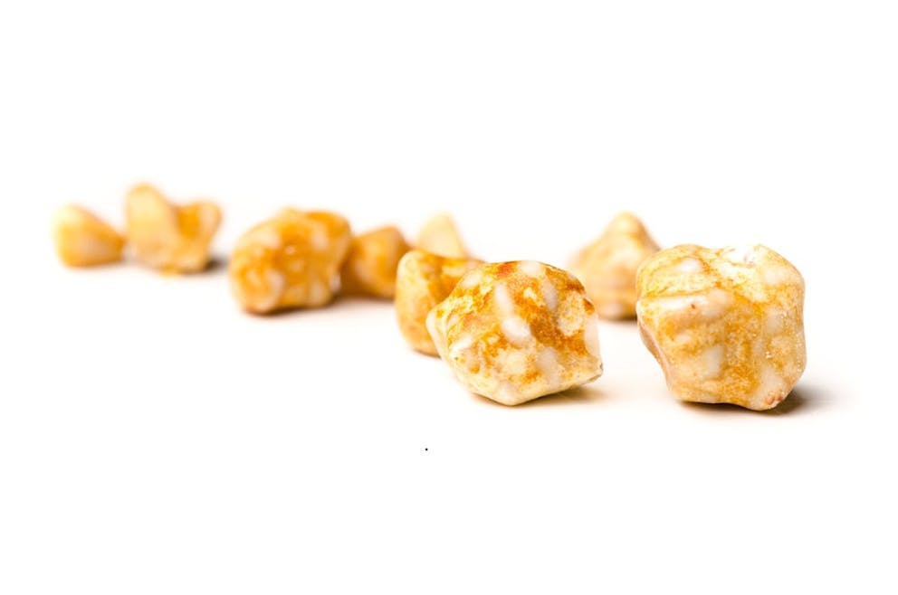 Yellowish brown gallstones on white background, gallstone attack