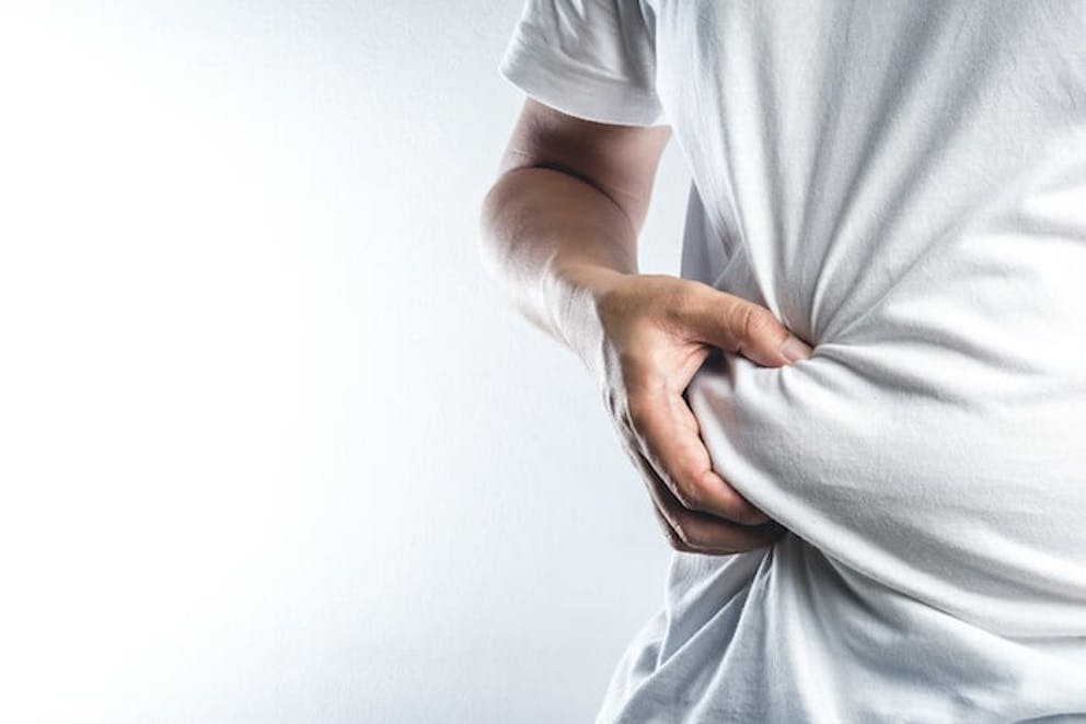 Man in white shirt pinching beer belly - liver body type 