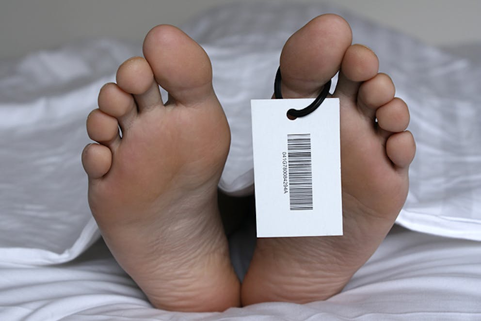 a picture of a dead person’s toes with a mortuary tag on one