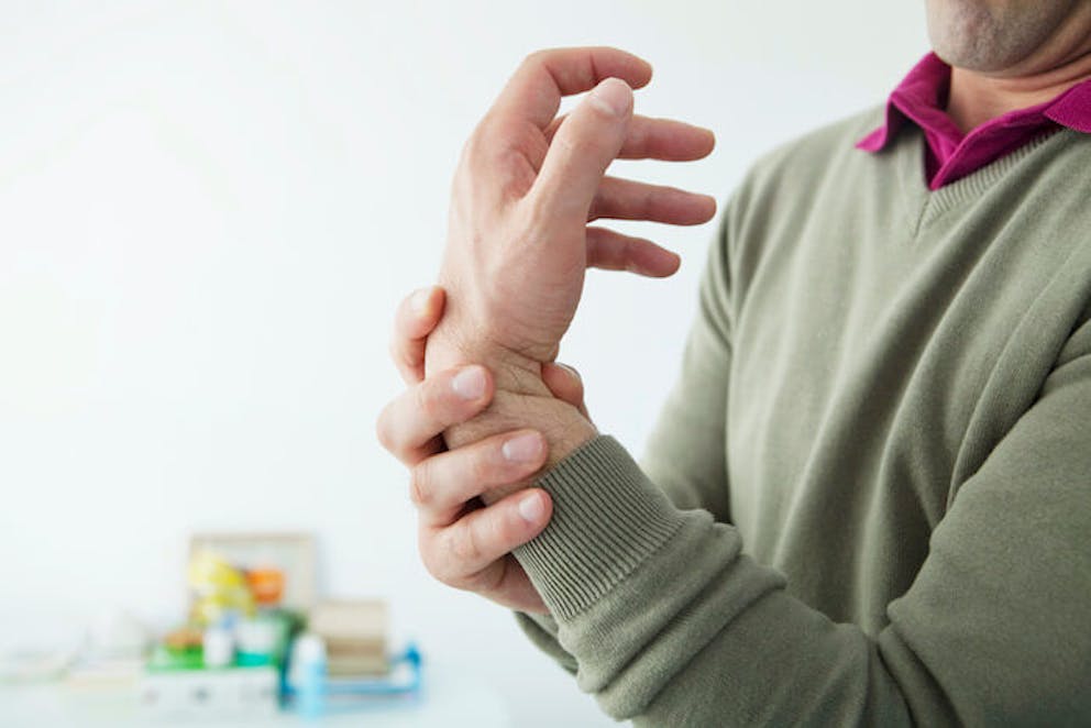 Man with carpal tunnel stretching wrist for pain relief | Wrist Pain Relief
