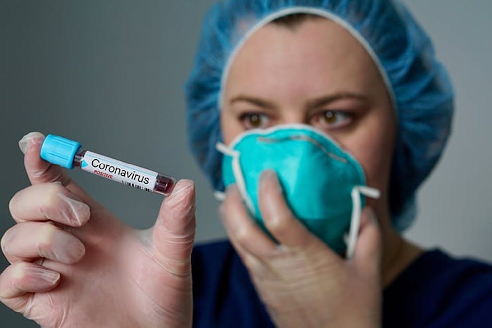 photo of a nurse holding a tube of blood labeled coronavirus