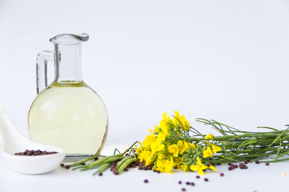 bottled rapeseed oil next to flower