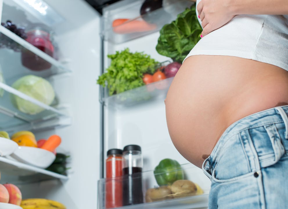 Pregnant woman in front of the fridge