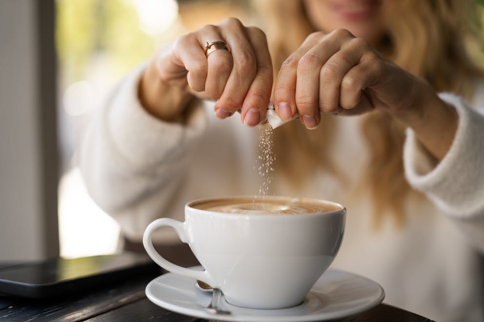 Woman sweetening coffee