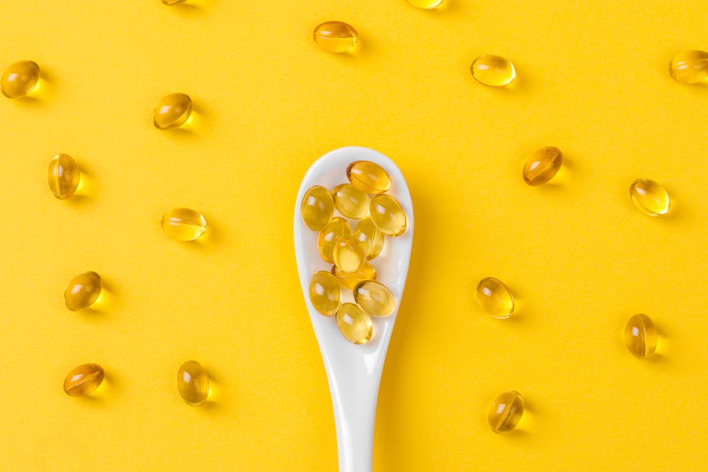 Vitamin D capsules on spoon